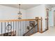Upper landing and staircase featuring a wooden banister, iron spindles, and a decorative pendant light at 730 Jackson Miller Cir, Powder Springs, GA 30127