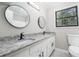 Updated bathroom with granite countertops, modern fixtures, dual mirrors, and a window view at 2450 Spring Mill Cv, Duluth, GA 30097