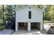 Two-car garage on a home with black trimmed doors and a narrow vertical window at 2450 Spring Mill Cv, Duluth, GA 30097