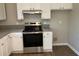 Bright kitchen features white cabinets, gray countertop, stainless steel range and wood floor at 2678 Brook Park Way, Atlanta, GA 30340