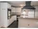 Bright kitchen with granite countertops, a black range hood, and stainless steel appliances at 115 Biscayne Dr # C2, Atlanta, GA 30309