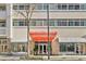 Exterior view of commercial building with red awning and storefronts on a sunny day at 805 Peachtree Ne St # 614, Atlanta, GA 30308