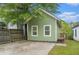 View of the exterior back of the home with fenced yard, parking pad, and green grass at 490 Rockwell Sw St, Atlanta, GA 30310