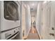 Hallway with hardwood floors, stacked washer/dryer, and white doors at 490 Rockwell Sw St, Atlanta, GA 30310
