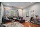 Spacious living room with hardwood floors, a large window, and a comfortable leather sectional at 490 Rockwell Sw St, Atlanta, GA 30310