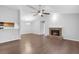 Open-concept living room with wood floors, a fireplace, and view to dining and kitchen at 130 Warm Springs Cir, Roswell, GA 30075