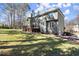 Exterior view of the home highlighting the backyard, deck, mature trees, and two-car garage at 1510 Habersham Pl, Cumming, GA 30041