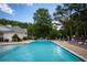 A sparkling swimming pool with lounge chairs and tables for relaxation in a wooded community at 1510 Habersham Pl, Cumming, GA 30041