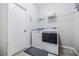 Modern laundry room featuring a side-by-side washer and dryer, a wire storage rack, and a sleek gray color palette at 2845 Jims Ne Rd, Marietta, GA 30066