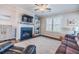 Comfortable living room with a fireplace, large windows, a ceiling fan, and a cozy leather sofa at 2845 Jims Ne Rd, Marietta, GA 30066