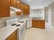 Well-lit kitchen featuring wood cabinets, laminate countertops, and modern white appliances at 123 Laurel Springs Dr, Mcdonough, GA 30253