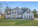 Charming two-story home with blue siding, well-manicured lawn, and meticulously landscaped flowerbeds at 2040 Winding Circle Trl, Fairburn, GA 30213