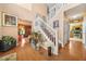 Welcoming foyer with hardwood floors, staircase with white railings, and views of the kitchen at 2040 Winding Circle Trl, Fairburn, GA 30213