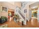 Open foyer with wooden floors, white stairs, and an adjacent view of the kitchen at 2040 Winding Circle Trl, Fairburn, GA 30213