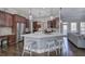 Large kitchen featuring marble countertops, stainless appliances, island with seating, and adjacent living area at 3759 Maryhill Nw Ln, Kennesaw, GA 30152