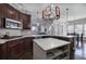 Stylish kitchen showcasing dark wood cabinets, marble countertops and backsplash, plus a white storage island at 3759 Maryhill Nw Ln, Kennesaw, GA 30152