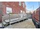 Enclosed backyard with gravel, wooden deck, brick wall, and exterior string lights at 409 Angier Ne Ct, Atlanta, GA 30312