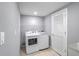 Practical laundry room including washer, dryer, a wire rack, and neutral tile floor at 409 Angier Ne Ct, Atlanta, GA 30312