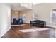 An open-concept living room with a tufted sofa, dining table, and hardwood floors, bathed in natural light at 409 Angier Ne Ct, Atlanta, GA 30312