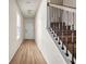 Inviting hallway with hardwood flooring and a staircase featuring wrought iron balusters at 5113 Rapahoe Trl, Atlanta, GA 30349