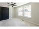 Bedroom with two windows and a closet featuring double doors and a ceiling fan at 526 Myrtle St, Villa Rica, GA 30180