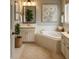 Bright bathroom with a soaking tub, vanity with sink, and stylish décor at 2431 Weatherstone Se Cir, Conyers, GA 30094