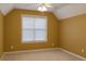 Empty bedroom featuring golden painted walls, ceiling fan, and light carpet at 2431 Weatherstone Se Cir, Conyers, GA 30094
