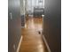 Hallway leading to the kitchen with hardwood flooring and gray and white paint at 2431 Weatherstone Se Cir, Conyers, GA 30094