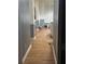 Kitchen view from a hallway featuring hardwood floors, stainless steel appliances, and white cabinets at 2431 Weatherstone Se Cir, Conyers, GA 30094