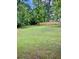 Open backyard featuring green lawn, mature trees, and wooden fencing at 2657 Langland Ne Ct, Atlanta, GA 30345