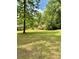Expansive backyard with lush green grass, mature trees, and a wood fence for privacy at 2657 Langland Ne Ct, Atlanta, GA 30345