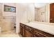 Well-lit bathroom featuring a marble countertop, custom vanity, and tiled shower at 2657 Langland Ne Ct, Atlanta, GA 30345