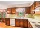 Traditional-style kitchen featuring wood cabinetry, white appliances, and a double basin sink at 2657 Langland Ne Ct, Atlanta, GA 30345