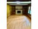 Spacious living room with wood paneling, a cozy brick fireplace, and hardwood floors at 2657 Langland Ne Ct, Atlanta, GA 30345