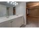 Bathroom featuring double sink vanity with white cabinets and large mirror and access to the bedroom at 308 Tulipwood Sw Cir, Conyers, GA 30094