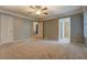 Neutral bedroom with soft carpeting, ceiling fan, and doorways leading to bathroom and walk-in closet at 308 Tulipwood Sw Cir, Conyers, GA 30094