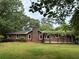 Charming single-story brick home with a lush green lawn and mature trees providing shade at 308 Tulipwood Sw Cir, Conyers, GA 30094