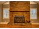 Rustic brick fireplace featuring a wood-burning stove and wood mantle at 308 Tulipwood Sw Cir, Conyers, GA 30094