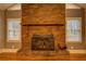 Close-up of brick fireplace with wooden mantel and a window at 308 Tulipwood Sw Cir, Conyers, GA 30094