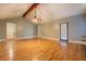 Open living room with hardwood floors, beamed ceiling, and a doorway at 308 Tulipwood Sw Cir, Conyers, GA 30094
