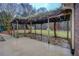 Covered outdoor patio with stone flooring and greenery-covered pergola at 308 Tulipwood Sw Cir, Conyers, GA 30094