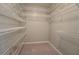 Walk-in closet features carpeted floor with multiple built in metal racks and shelves at 308 Tulipwood Sw Cir, Conyers, GA 30094