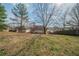 Expansive backyard with gentle slope featuring budding grass, bordered by a wooden fence and mature trees at 4932 Wilkins Station Dr, Decatur, GA 30035