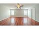 Spacious primary bedroom featuring wood floors, neutral walls, ceiling fan, and two windows at 4932 Wilkins Station Dr, Decatur, GA 30035