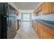 Functional galley kitchen featuring wood cabinets, granite counters, and black appliances at 4932 Wilkins Station Dr, Decatur, GA 30035