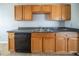 Functional galley kitchen featuring wood cabinets, granite counters, and black appliances at 4932 Wilkins Station Dr, Decatur, GA 30035