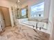 Bathroom suite featuring a soaking tub, a glass-enclosed shower, and marble-like tile at 532 Healy Dr # 61, Cumming, GA 30040