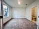 A minimalist bedroom with neutral carpet and an attached bathroom visible through the doorway at 532 Healy Dr # 61, Cumming, GA 30040