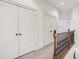 Upstairs hallway featuring carpet, white doors, dark bronze hardware, and a decorative wood railing at 911 Telfair Close, Sandy Springs, GA 30350