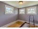 Bedroom with hardwood floors, three windows, and soft lilac-painted walls at 3670 Union Ave, Atlanta, GA 30354